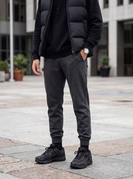 Vomero 5 – A cozy athleisure ensemble consisting of charcoal grey fleece joggers, a matching oversized hoodie, and a black puffer vest for cooler weather.
