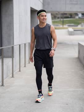 High-performance black compression tights, a moisture-wicking charcoal grey sleeveless tech tee, and a matching lime green headband for a cohesive running look.