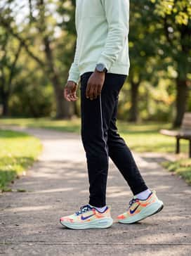 Tapered black track pants with white side-striping, a slim-fit quarter-zip pullover in pale mint green, and a high-end sport watch for a polished post-workout ensemble.