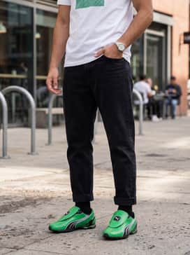 Vs1 Contact Mens Sneakers – Relaxed-fit black denim jeans with a crisp white long-sleeve tee featuring subtle green branding, topped with a sleek black nylon bomber jacket.