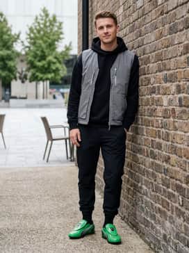 Vs1 Contact Mens Sneakers – Techwear-inspired matte black joggers paired with a reflective grey utility vest layered over a black slim-fit hoodie to emphasize the shoe's futuristic silhouette.