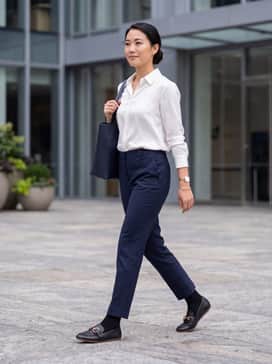 Navy tailored ankle-length trousers paired with a crisp white silk button-down and a minimalist gold watch to match the buckle.