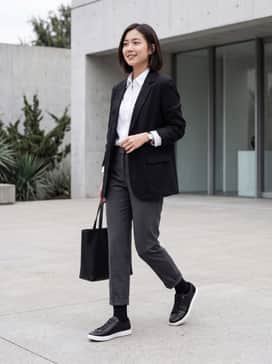 A pair of black skinny jeans paired with a crisp white button-down shirt and a tailored grey wool coat for a sophisticated monochromatic look.