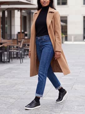 Straight-leg indigo denim with a tucked-in black turtleneck sweater and a camel-colored trench coat to balance the sporty sole with classic outerwear.