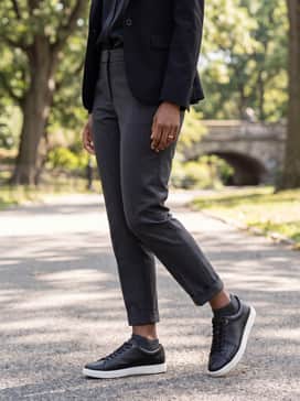 Ankle-length charcoal trousers, a black silk blouse, and a structured blazer for a modern, office-ready business casual ensemble.