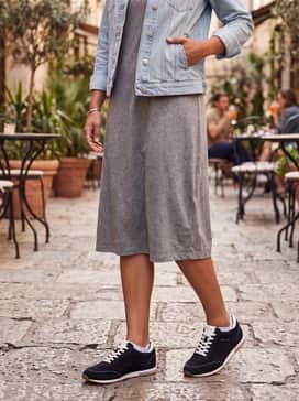 A heather grey midi t-shirt dress layered under a light-wash denim jacket, creating a breezy and effortless ensemble for a casual brunch.