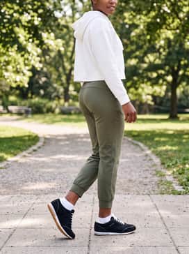 Olive green tailored joggers and a slim-fit white cropped hoodie for a refined athleisure vibe that is perfect for travel or running errands.
