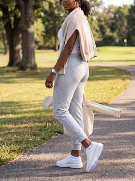 Womens Grandpr Topspin Waterproof Golf Shoes – Light grey tapered joggers paired with a fitted white tank top and an oversized beige cardigan for a comfortable travel or errands ensemble.