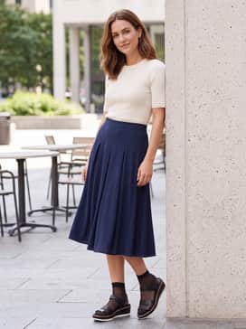Dark wash skinny jeans with a slightly frayed hem, worn with an oversized pinstripe button-down shirt for a balanced mix of masculine and feminine styles.