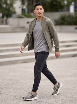 Black slim-fit joggers paired with a heather grey moisture-wicking t-shirt and a lightweight olive bomber jacket for a coordinated athletic look.