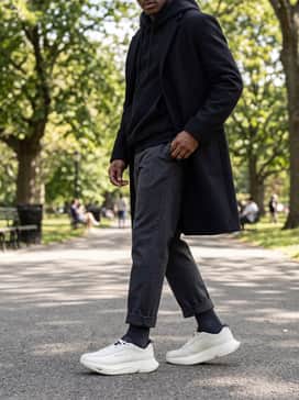 Y3 Adios Pro 30 Lx – An avant-garde streetwear silhouette using oversized charcoal wool trousers that are cuffed at the ankle, paired with a voluminous black hoodie and a structured longline coat.