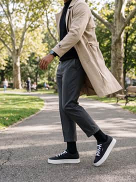 York – Charcoal grey cropped trousers, a tucked-in black mock-neck sweater, and a beige trench coat for a sophisticated smart-casual office transition.