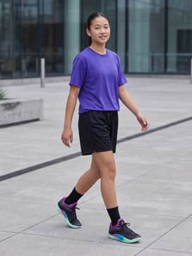 Zion 4 Noah – High-performance black mesh basketball shorts paired with a compression tee in electric purple and matching black crew socks to keep the focus on the footwear.