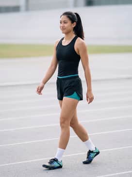 A black high-performance compression singlet paired with matching teal-lined track shorts for a streamlined competition look.