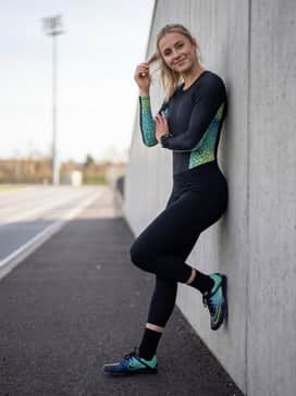 A sleek, black aerodynamic racing suit with subtle electric blue detailing to complement the shoe's secondary color theme.