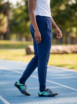 Lightweight tapered track joggers in deep navy blue paired with a breathable white technical tee for warm-up drills.