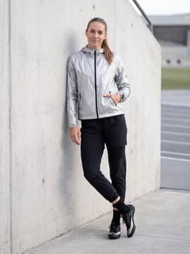 A technical warm-up set consisting of tapered black track pants and a reflective silver windrunner jacket for early morning heats.