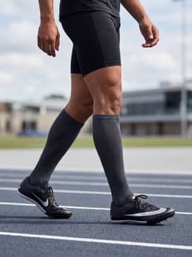 A fitted neon green performance t-shirt with black aerodynamic running tights and a matching silver headband for high-visibility training.