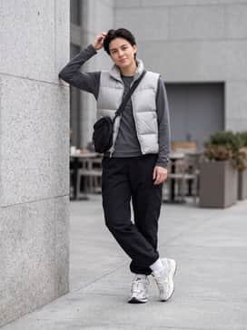 Black nylon cargo pants with adjustable bungee cords, a cropped silver puffer vest, and a tech-focused crossbody bag for a futuristic urban look.